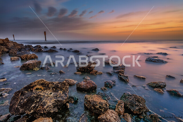 الاستمتاع بالمناظر الطبيعة الهادئة، صورة مقربة لشاطئ صخري في مدينة الخبر، أماكن سياحية مشهورة في المملكة العربية السعودية، انعكاس أشعة الشمس على البحر في وقت الغروب