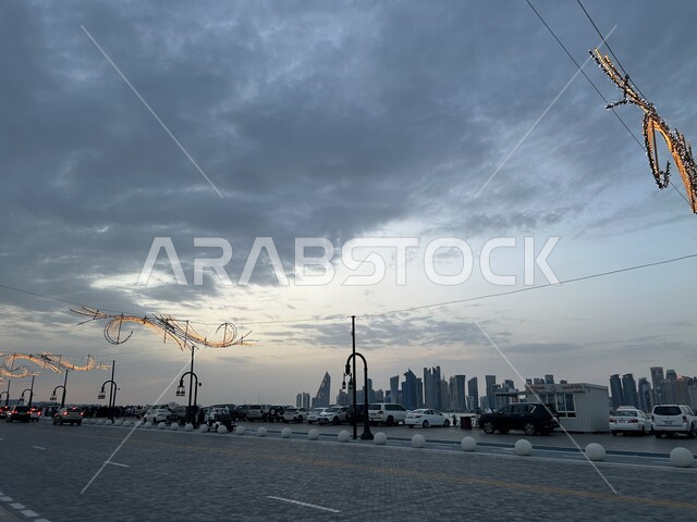 Towers, skyscrapers and high buildings, a view of the sky full of clouds at sunset, urban growth and progress in roads and buildings, Doha Port in Qatar
