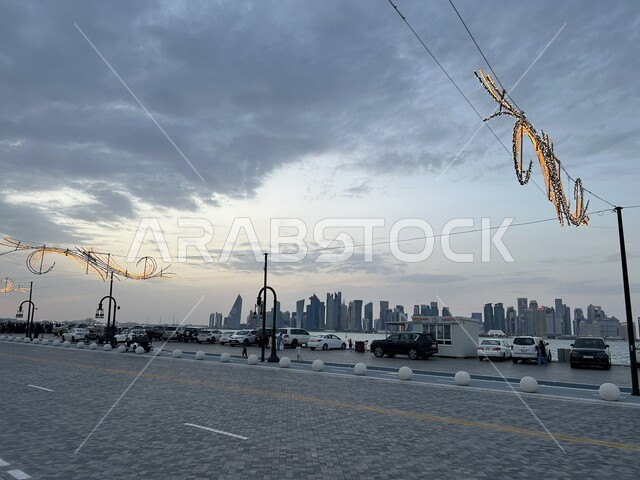مشهد للسماء المليئة بالغيوم في وقت الغروب, النمو والتقدم العمراني في الطرقات والمباني, ميناء الدوحة في قطر, خلفية الابراج وناطحات السحاب والعمائر العالية