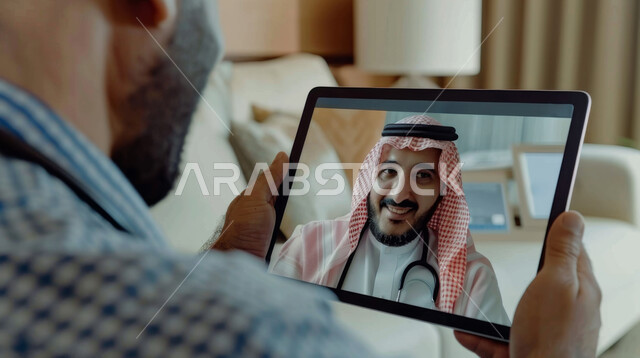 تقديم الخدمات الطبية والرعاية الصحية عن بعد، الاستفادة من التكنولوجيا والتقنيات الحديثة, رجل عربي خليجي سعودي يجلس في بيته يتلقى استشارة طبية من الطبيب عن طريق الجهاز اللوحي, مفهوم الطب والعناية بالمرضى
