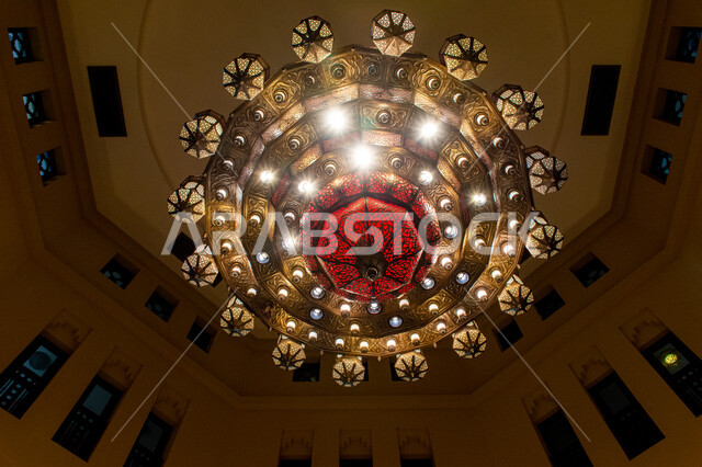 ديكورات داخلية وتصاميم مستوحاة من التراث القديم, ثرية حديدية معلقة ذات فوانيس مضاءة بألوان جذابة, إضاءة وقناديل مزخرفة داخل مبنى أثري قديم