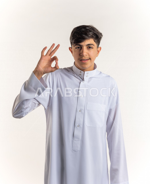 بورتريه شاب مراهق سعودي خليجي سعيد بإيماءات الوجه المختلفة ، تعابير وجه و يدين مختلفة ، خلفية بيضاء