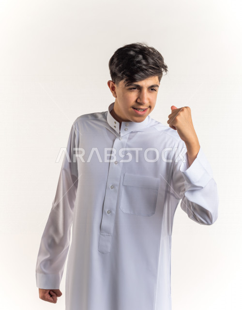 Portrait of a young Saudi Arabian Gulf teenager doing biceps movement with different facial and hand gestures, white background, enjoying good physical health