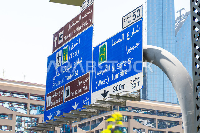 The use of directional signs on main roads, the urban renaissance in construction and streets in the Emirates, a large blue directional signboard in Arabic and English on Sheikh Zayed Road in Dubai, roads and public transportation.