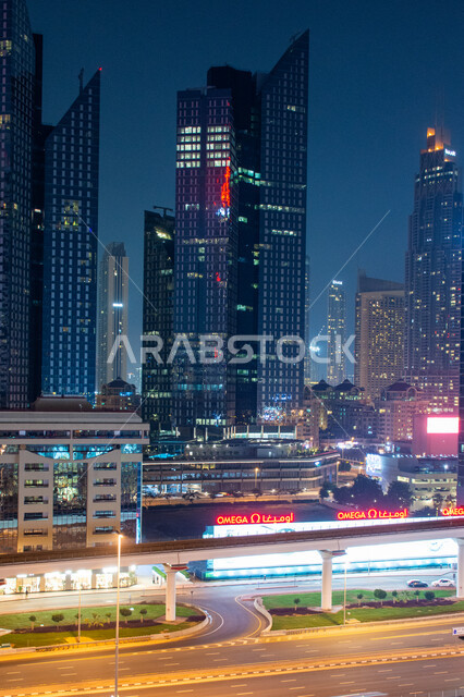 المباني الشاهقة المضيئة في الليل في شارع الشيخ زايد بمدينة دبي بالإمارات العربية المتحدة, التطور في بناء الأبراج وناطحات السحاب, التصاميم الهندسية البديعة للفنادق والعمارات العالية, النهضة العمرانية الكبيرة في الإمارة