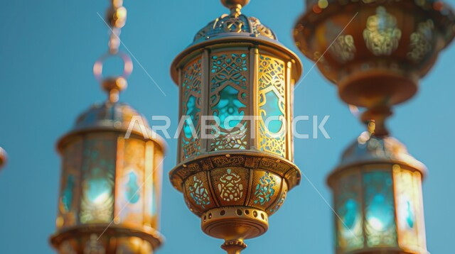 الاحتفال بقدوم شهر رمضان المبارك، صورة مقربة لمجموعة من الفوانيس المزخرفة المعلقة، أجواء رمضانية إسلامية روحانية هادئة, زينة الأعياد والمناسبات الدينية، منظر السماء الزرقاء الصافية