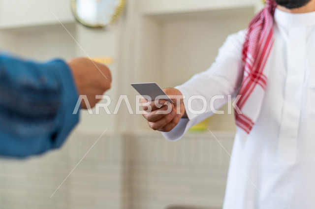 صورة مقربة لموظف إستقبال خليجي سعودي يعطي كرت المفتاح لنزيلة سعودية محجبة في الفندق السياحي , سياحة وفندقة , خدمة عملاء ومكتب إستقبال العملاء , إجراءات الحجز والإستفسار , سياحة وسفر