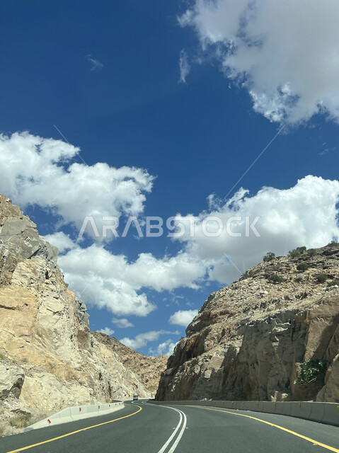 الممرات والطرقات المعبدة، التضاريس والمرتفعات الجبلية، منظر الغيوم البيضاء في السماء، التكوينات والتشكيلات الطبيعية للصخور والحجارة، معالم وأماكن سياحية في السعودية، الطريق السريع لجبال الشفا في مدينة الطائف بالمملكة