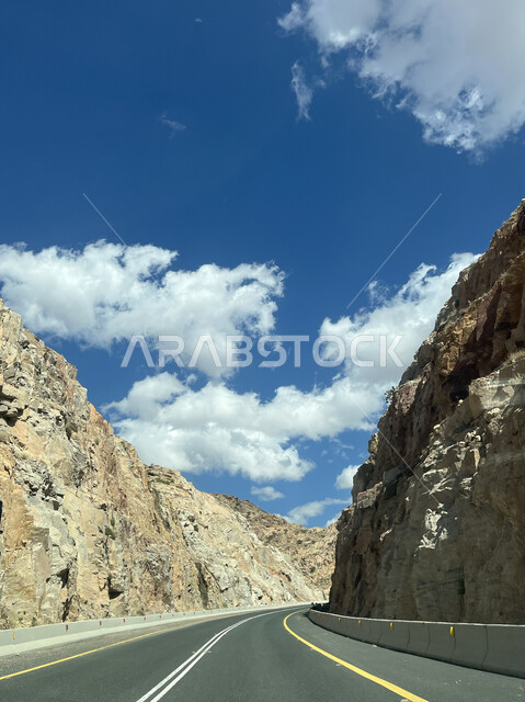 التضاريس والمرتفعات الجبلية، منظر الغيوم البيضاء في السماء، التكوينات والتشكيلات الطبيعية للصخور والحجارة، معالم وأماكن سياحية في السعودية، الطريق السريع لجبال الشفا في مدينة الطائف بالمملكة، الممرات والطرقات المعبدة