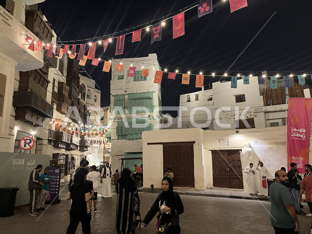 النوافذ الخشبية والأبنية القديمة في وقت الليل، توافد الزوار إلى البلدة الاثرية في شهر رمضان المبارك، زينة وأضواء الشهر الفضيل، الفن الهندسي المعماري على الطراز العربي الإسلامي، القرية التاريخية في مدينة جدة، أماكن سياحية جذابة في المملكة العربية السعودية