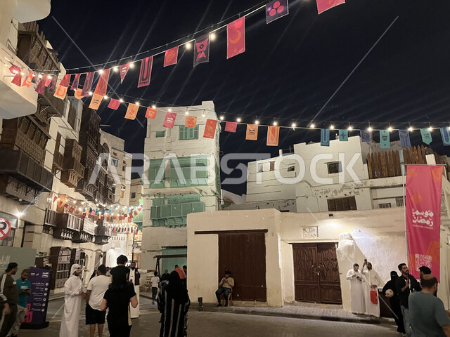 توافد الزوار إلى البلدة الاثرية في شهر رمضان المبارك، زينة وأضواء الشهر الفضيل، الفن الهندسي المعماري على الطراز العربي الإسلامي، القرية التاريخية في مدينة جدة، أماكن سياحية جذابة في المملكة العربية السعودية، النوافذ الخشبية والأبنية القديمة في وقت الليل