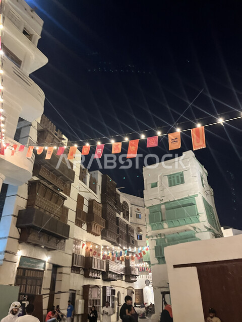 زينة وأضواء الشهر الفضيل، توافد الزوار إلى البلدة الاثرية في شهر رمضان المبارك، الفن الهندسي المعماري على الطراز العربي الإسلامي، القرية التاريخية في مدينة جدة، أماكن سياحية جذابة في المملكة العربية السعودية، النوافذ الخشبية والأبنية القديمة في وقت الليل