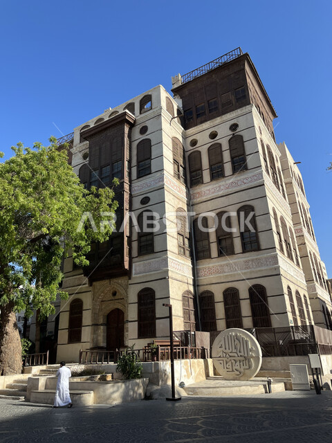 القرية التاريخية في مدينة جدة، الفن الهندسي المعماري على الطراز العربي الإسلامي، النوافذ الخشبية والأبنية القديمة في وقت النهار، أماكن سياحية جذابة في المملكة، الاهتمام بزراعة الأشجار الخضراء في السعودية