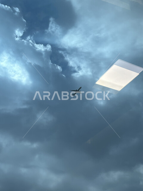 طائرة تحلق في سماء المملكة العربية السعودية الملبدة بالغيوم، الاستمتاع بمشاهدة المناظر الطبيعية الهادئة، تجمع السحب البيضاء والرمادية استعدادا لهطول المطر فوق مدينة جدة