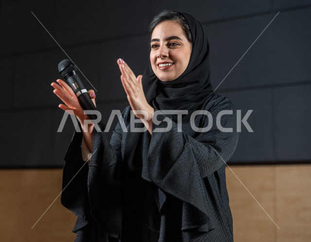 Saudi-Gulf women performing theatrical presentation on stage, interacting with the audience, presenting theatrical performances, giving speeches, dialogues and discussions, acting performance, different face and hand gestures, theatrical art