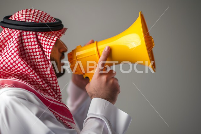 استخدام المايك للاعلان عن شيئ ما، بورتريه مقرب لرجل عربي خليجي سعودي يرتدي الثوب التقليدي والشماغ يحمل بيده مكبر الصوت باللون الاصفر، المناداه والاعلان ولفت الانتباه، خلفية بيضاء