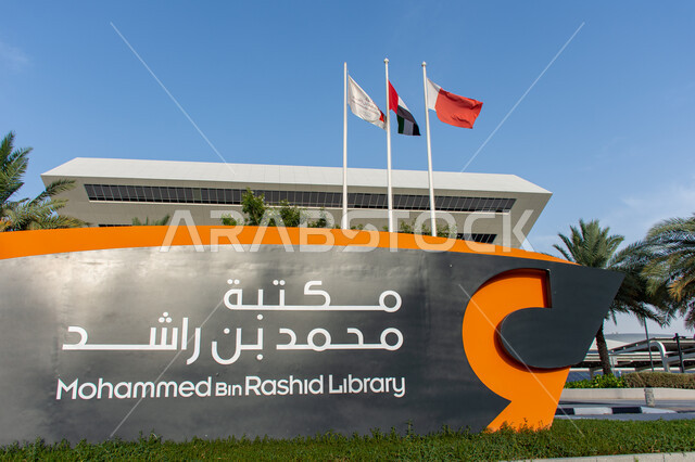 لوحة عنوان باللغتين العربية والانجليزية لمكتبة محمد بن راشد بمدينة دبي بالإمارات العربية المتحدة، معالم مدينة دبي الثقافية المشهورة, المنارات الفكرية الاماراتية, سارية للعلم الاماراتي يرفرف في سماء الوطن