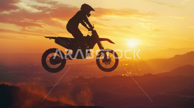ممارسة التمارين لحرق الدهون و إنقاص الوزن, هواية ركوب الدراجة, نشاط بدني للمحافظه على الصحه واللياقه الجسدية, منظر السماء في وقت الغروب, صورة ظلية لمغامر عربي يقود الدراجة الكهربائية في الصحاري والمرتفعات الجبلية