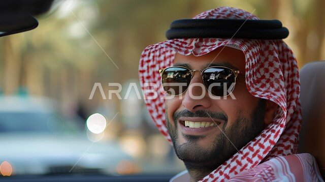 مفهوم الرجولة والثقة بالنفس، الأناقة والاهتمام بالمظهر الخارجي، صورة مقربة لرجل عربي خليجي سعودي مبتسم يرتدي الثوب التقليدي والشماغ يضع النظارة الشمسية، ايماءات السرور والسعادة