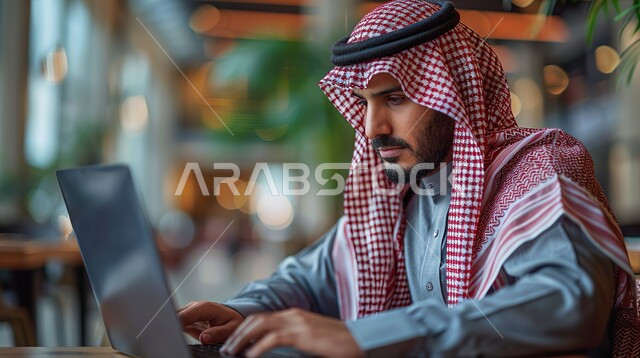 مهن ووظائف ادارية مكتبية، دمج العمل مع التكنولوجيا، إدارة شؤون الأعمال وتنظيمها عبر الاجهزة التقنية، صورة مقربة من الجانب لرجل اعمال عربي خليجي سعودي يرتدي الزي التقليدي والشماغ يعمل على الحاسوب المحمول