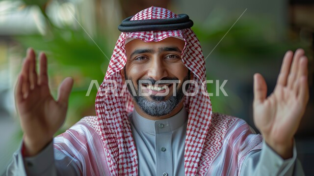 حركات وايماءات البهجة والسرور برؤية شخص ما، خلفية الطبيعة، الترحيب والاستقبال بحرارة وحب، صورة مقربة لرجل عربي خليجي سعودي يرتدي الزي التقليدي ينظر الى الكاميرا بتعابير السعادة،
