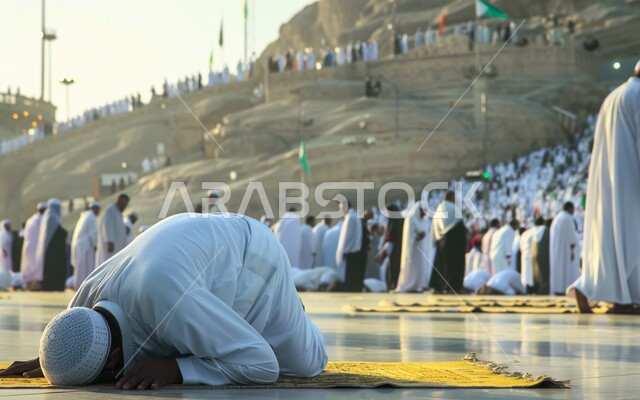 الصلاة والخشوع والدعاء, العبادة والتقرب إلى الله تعالى, حاج مسلم يرتدي ثياب الاحرام يقوم بالسجود في منطقة جبل عرفات, أداء مناسك الحج في مكة المكرمة, أماكن إسلامية مشهورة في السعودية