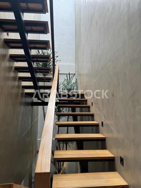 التصميم الحديث لدرج خشبي داخل المنزل, الديكورات الداخلية المعاصرة للشقق السكنية في السعودية, السلالم الخشبية الواصلة بين طوابق الفلل في المملكة, سلم مريح وعملي