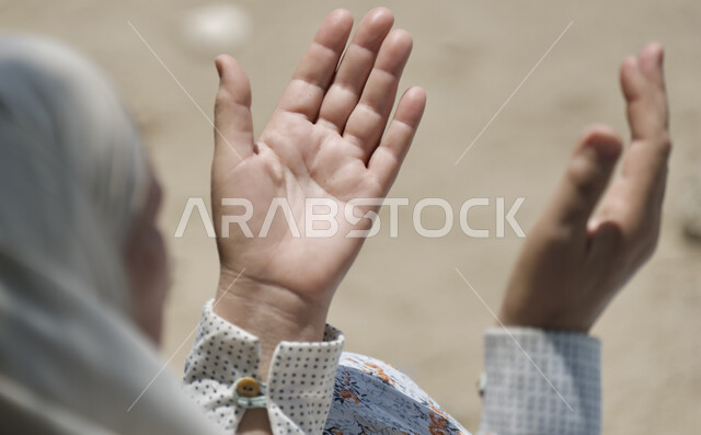 العباده والتقرب الى الله، صورة مقربة لأيدي امرأة مسلمة عربية خليجية سعودية ترفع يديها للدعاء، التضرع و طلب العون والحمد والشكر