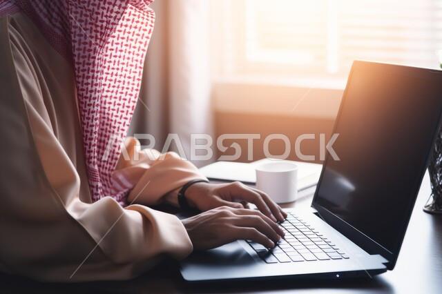 Using modern and advanced devices in performing work, office administrative professions and jobs, close-up image of the hands of a Saudi Arabian Gulf businessman clicking on a laptop, comfortable work environment in Saudi companies
