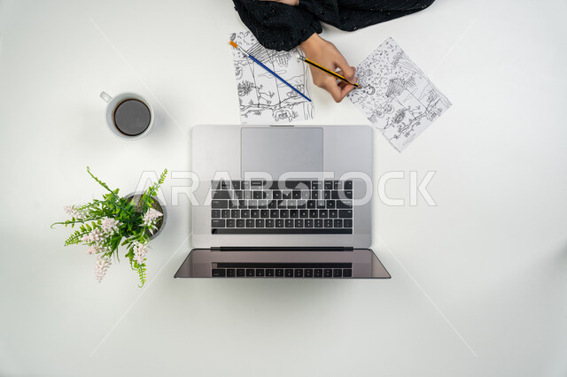 البيع والشراء عبر الانترنت، التدريب والتعلم من خلال المواقع الإلكترونية، بورتريه علوي عامودي ليدي إمرأة عربية خليجية اماراتية تقوم بالرسم بقلم الرصاص، شابة سعودية تستخدم جهاز الحاسوب، الحصول على الألوان المائية والخشبية ومستلزمات الرسم أونلاين، خلفية بيضاء