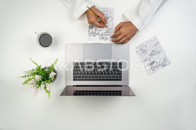 ممارسة الهوايات المفضلة, دمج التقنيات الحديثة بالأعمال الفنية, بورتريه علوي عامودي ليدين رسام عربي خليجي إماراتي يقوم بالرسم على ورقة باستخدام قلم الرصاص, الاستعانة بجهاز الحاسوب للحصول على برامج المساعدة, خلفية بيضاء