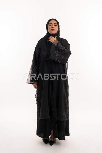 الشعور بالمرض والكحة، تعابير الالم والارهاق، الانفلونزا والتهاب الرئة، بورتريه لامرأة عربية خليجية اماراتية محجبة ترتدي عباءة سوداء تضع يدها حنجرتها بايماءات التوجع، شابة سعودية مريضة، صورة لكامل الجسم، خلفية بيضاء