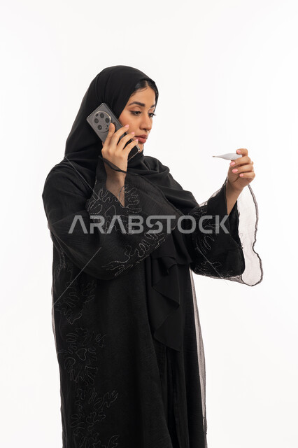 استخدام الأجهزة الحديثة، إجراء مكالمة صوتية عبر الهاتف المحمول, الإحساس بالمرض والإرهاق، الإصابة بالحمى والتعب، بورتريه من الجانب لامرأة عربية خليجية اماراتية محجبة تقوم بقياس حرارتها باستخدام الميزان الرقمي، الحاجة لزيارة الطبيب، شابة سعودية مريضة، خلفية بيضاء