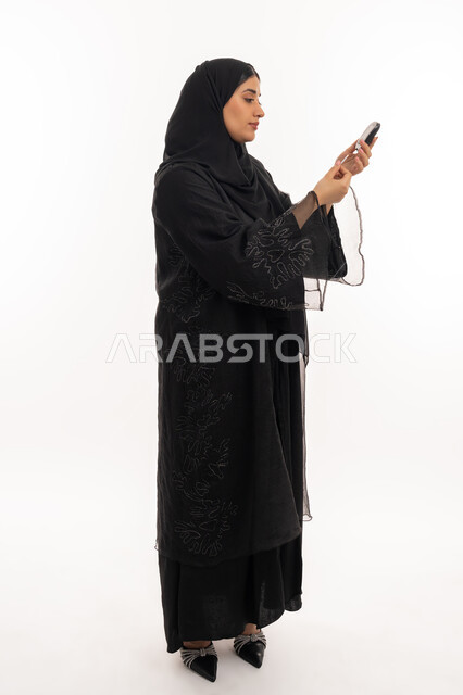 حالات مرضية ومشاكل وآلام جسدية, مشاكل ارتفاع السكر في الدم, جهاز إلكتروني حديث لمرضى داء السكري, الرعاية الصحية والفحص الطبي السريع, بورتريه من الجانب لامرأة عربية خليجية إماراتية تقوم بفحص نسبة السكر في الدم, شابة سعودية مريضة، صورة لكامل الجسم، خلفية بيضاء