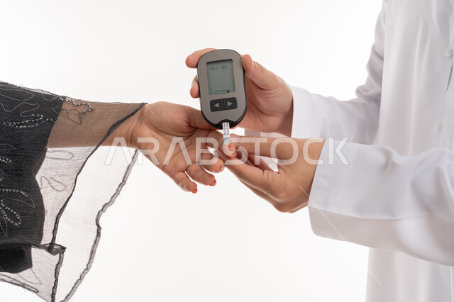 مشاكل ارتفاع السكر في الدم, جهاز إلكتروني حديث لمرضى داء السكري, حالات مرضية ومشاكل وآلام جسدية, الرعاية الصحية والفحص الطبي السريع, بورتريه مقرب ليد امرأة عربية خليجية إماراتية تقوم بفحص نسبة السكر في الدم, شابة سعودية مريضة، خلفية بيضاء