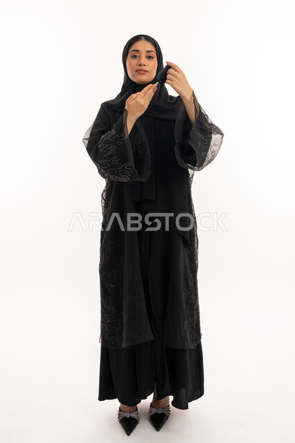 حالات مرضية ومشاكل وآلام جسدية, مشاكل ارتفاع السكر في الدم, جهاز إلكتروني حديث لمرضى داء السكري, الرعاية الصحية والفحص الطبي السريع, بورتريه لامرأة عربية خليجية إماراتية تقوم بفحص نسبة السكر في الدم, شابة سعودية مريضة، صورة لكامل الجسم، خلفية بيضاء