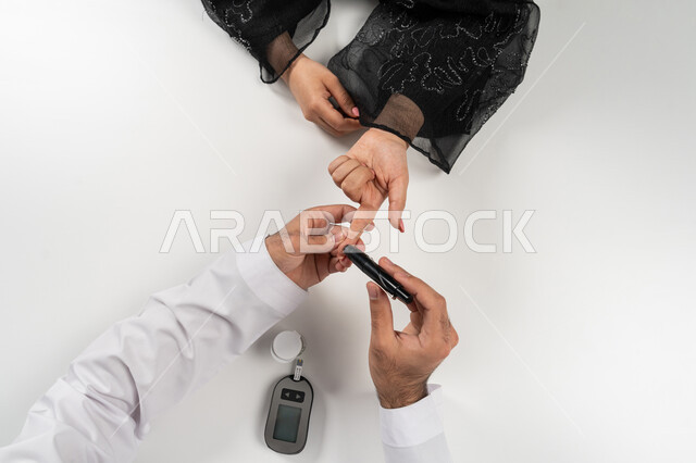 مشاكل ارتفاع السكر في الدم, الرعاية الصحية والفحص الطبي السريع, حالات مرضية ومشاكل وآلام جسدية, جهاز إلكتروني حديث لمرضى داء السكري, بورتريه علوي عامودي ليد امرأة عربية خليجية إماراتية تقوم بفحص نسبة السكر في الدم, شابة سعودية مريضة، خلفية بيضاء
