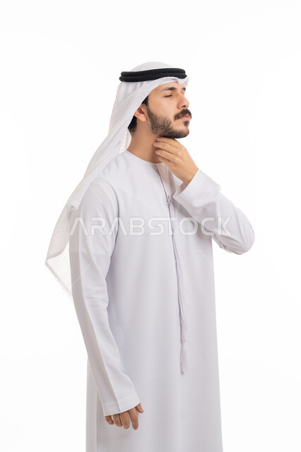 الاحساس بألم البلعوم, الحاجة إلى العلاج والدواء, مفهوم الاهتمام بالصحة, الاصابة بنزلة برد والتهاب الحلق، بورتريه لشاب عربي خليجي إماراتي يرتدي الكندورة والغترة يضع يديه على حلقه ويشعر بالاختناق,  خلفية بيضاء