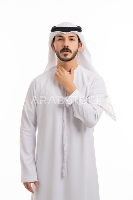 العدوى بفايروس كورونا, النظر إلى الكاميرا بإيماءات صعوبة التنفس والتعب والألم, الاصابة بنزلة برد والتهاب الحلق، بورتريه لشاب عربي خليجي إماراتي يرتدي الكندورة والغترة يضع يديه على حلقه ويشعر بالاختناق، المرض الشديد والسعال، خلفية بيضاء