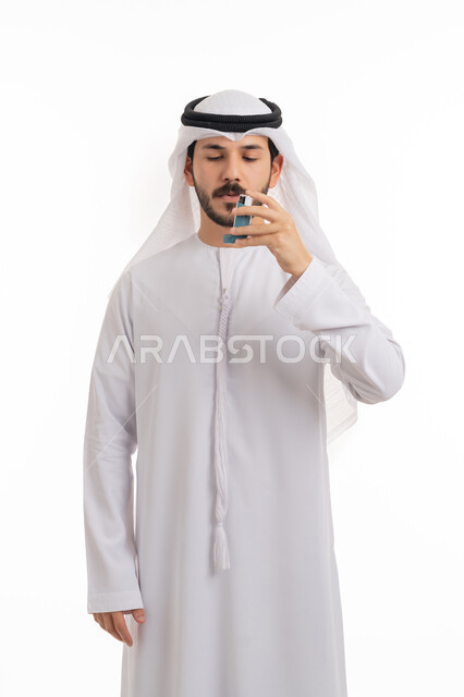مشاكل في الجهاز التنفسي، بورتريه لرجل عربي خليجي اماراتي يرتدي الكندورة والغترة الاماراتية يحمل بيده جهاز الرذاذ الخاص بمرض الربو، أجهزة استنشاق المخصصة للمرضى، المحافظة على ممر هوائي منتظم، خلفية بيضاء