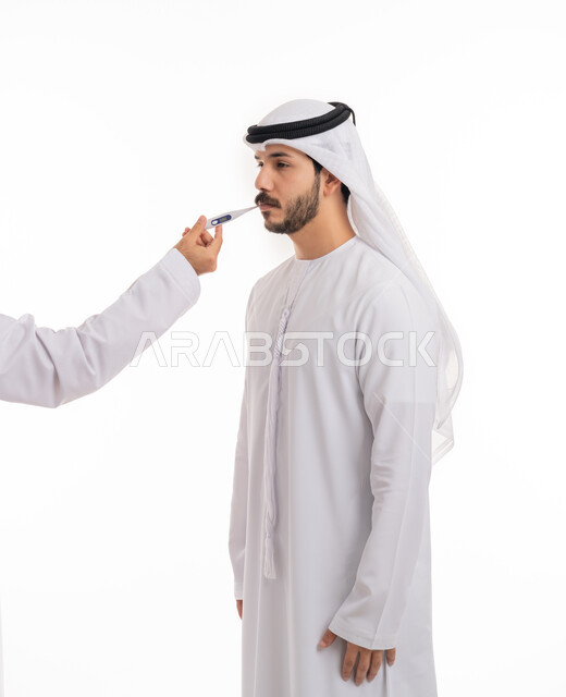 الإحساس بالمرض والإرهاق، اتباع إجراءات السلامة والوقاية، الحاجة للمساعدة وزيارة الطبيب، الإصابة بالحمى والتعب, بورتريه من الجانب لرجل عربي خليجي إماراتي يرتدي الكندورة والغترة الاماراتية يقوم بقياس درجة حرارته باستخدام الميزان الرقمي, خلفية بيضاء