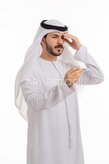 المرض والإرهاق والاحساس بنوبة الشقيقة، ضرورة زيارة الطبيب لوضع الخطة العلاجية، بورتريه لشاب عربي خليجي إماراتي يرتدي الكندورة والغترة ينظر إلى مؤشر الميزان الرقمي بتعابير الانزعاج والتعب, خلفية بيضاء