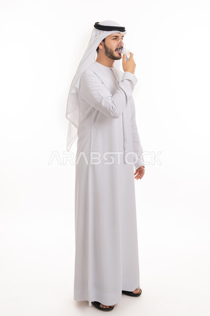 المحافظة على ممر هوائي منتظم باستخدام جهاز التنفس الصناعي، بورتريه لرجل عربي إماراتي خليجي يرتدي الكندورة والغترة يقوم باستنشاق أدوية معالجة لانقطاع التنفس عن طريق قناع الاكسجين، مداواة أمراض الربو المزمنة, صورة الجسم بالطول الكامل, خلفية بيضاء