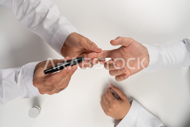 A modern electronic device for patients with diabetes, medical conditions, problems and physical pain, a vertical overhead portrait of an Arab Gulf Emirati man checking his blood sugar level, health care and rapid medical examination, white background