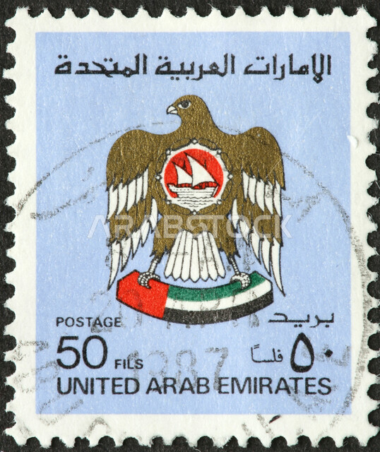 Old postage stamp with the image of the eagle and the UAE emblem, marks for envelopes and letters to prove payment of fees, stamps for official documents in the United Arab Emirates