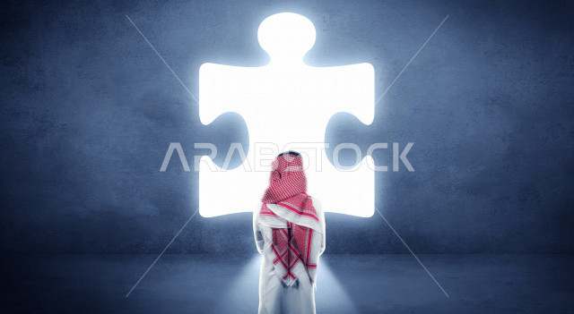 تصوير من الخلف لرجل شاب سعودي خليجي يسعى لمواجهة الضغوطات والازمات ، طرق وحلول لمواجهة الازمة ، التخطيط الجيد لحل الالغاز والمشكلات ، مع خلفية شكل لغز