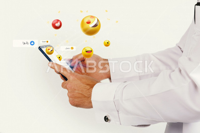 صورة مقربة ليد رجل خليجي سعودي بيده الهاتف المحمول   ، يستخدام مواقع التواصل الإجتماعي ،التفاعل مع الاصدقاء والمحادثات ،استخدام الإيموجي  ،التقاعل مع العالم الافتراضي