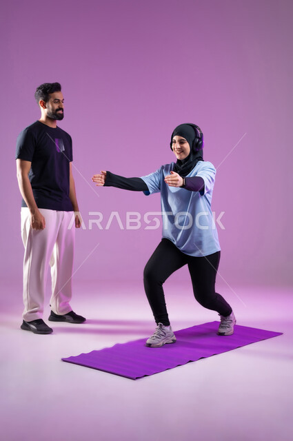 ثني القدم للامام وللخلف للقيام بالاحماء، مد اليدين للامام استعداداً للقيام بحركة السكوات،بورتريه لشابة عربية خليجية سعودية ترتدي سماعه الهيدفون، اسلوب حياة صحي، مفهوم الرشاقة واللياقة البدنية، انشطة ورياضات لتقوية العضلات,  المحافظة على التوازن الجسدي, خلفية بنفسجية