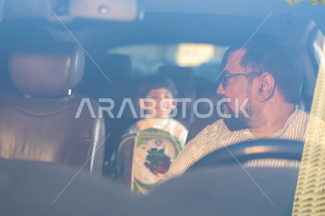 استقدام العمالة من الخارج، مفهوم القيادة والتوصيل، مهن ووظائف سعودية، سائق باكستاني مبتسم يرتدي النظارة الطبية يقوم بنقل طفل عربي خليجي سعودي يتبادلان الأحاديث بإيماءات الفرح والسرور