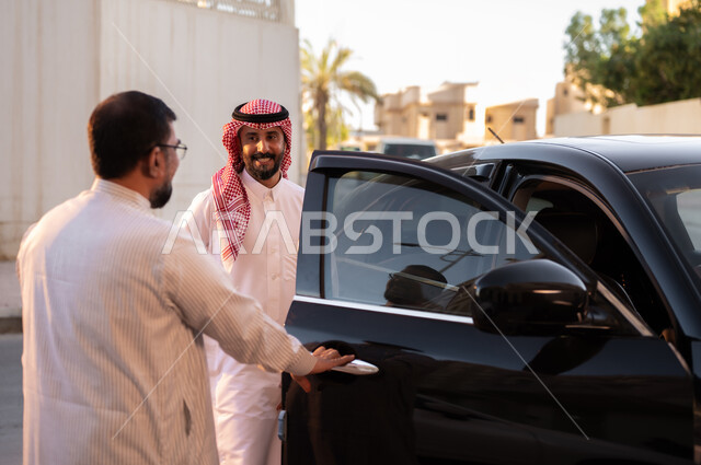 وظائف ومهن سعودية، استقدام العمالة من الخارج، سائق باكستاني يرتدي النظارة الطبية يقوم بفتح باب السيارة لرجل عربي سعودي خليجي يرتدي الشماغ والثوب التقليدي بإيماءات السرور، مفهوم القيادة والتوصيل، نهاية دوام العمل